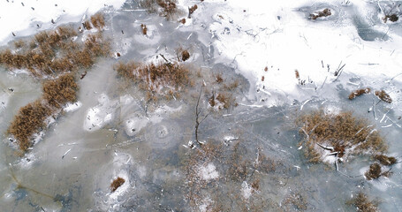 Aerial winter lake. River ice. Snowy nature scenery white ground covering snowfall frozen countryside lake cold cloudy weather.