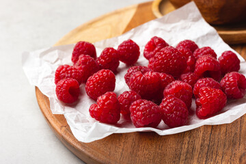 Raspberries on a white paper on a light background