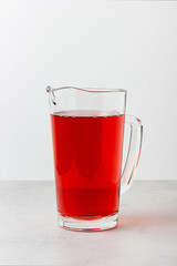 Red color drink in the glass jug