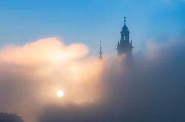 Krakow, Poland, Wawel cathedral towers shrouded in the fog, sunlit in the morning - 684325700
