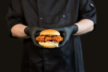 A craft juicy burger with cheese is held in the hands