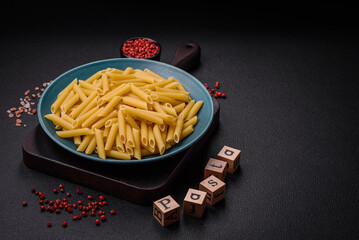Raw penne pasta from whole grain wheat varieties with salt and spices