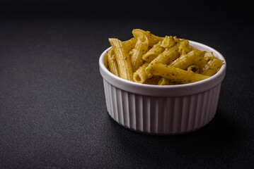 Delicious fresh pasta penne with green pesto sauce with basil, salt and spices
