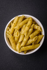 Delicious fresh pasta penne with green pesto sauce with basil, salt and spices