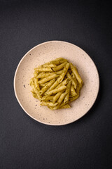 Delicious fresh pasta penne with green pesto sauce with basil, salt and spices