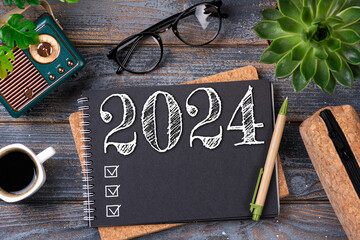 New year resolutions 2024 on desk. 2024 resolutions list with notebook, coffee cup on table. Goals,...