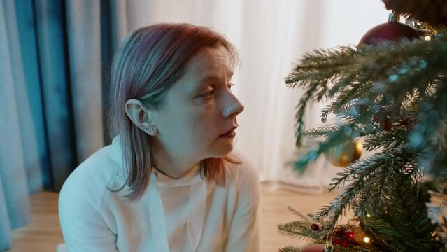 Depressed and lonely woman feeling bad on Christmas at home. Emotional stress and problems with mental health on Christmas Eve, the moment that you realize no one can help you except yourself.