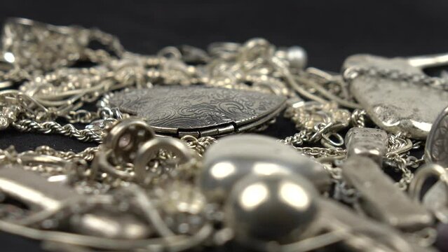 Vintage silver jewelries of various forms and functions lie on a black cloth. Inheritance, family collection