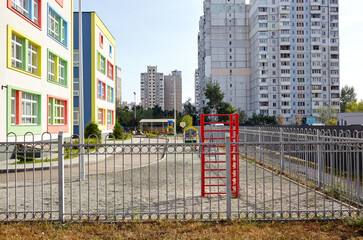Facade of kindergarten building. Colorful playground for childrens on a sunny day