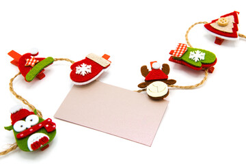Greeting blank card hanging on a rope on clothespins isolated on white background. Christmas, New Year, St. Nicholas Day. Winter holidays. Copy space. Free space for text.	