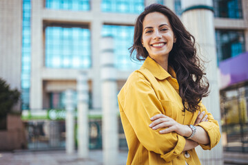 Portrait of a confident young businesswoman standing against an urban background. Portrait of...