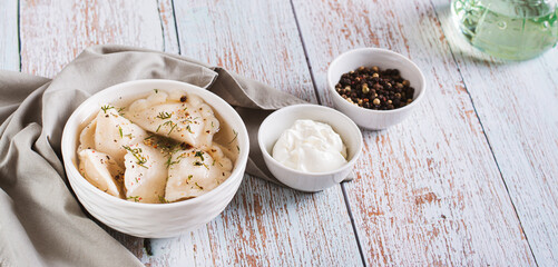 Obraz na płótnie Canvas Traditional dumplings soup with herbs and spices in a bowl on the table web banner