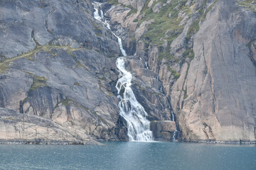 Waterfalls are plentiful in Prince Christian Sound as glaciers melt into the sea, Greenland.
