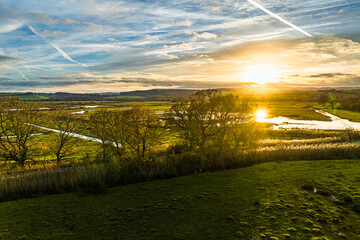 Sunset over Wetlands and Marshes in RSPB Exminster and Powderham Marshe from a drone, Exeter, Devon, England