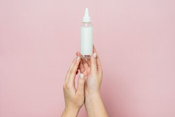 Cosmetic bottle in woman's hands. Cosmetic product branding mockup. Daily skincare and body care routine.