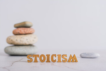 Concept stoicism word made from letters and pyramid of stones on gray background