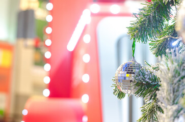 Disco ball hanging on christmas tree.