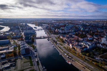 Fototapeta premium Szczecin from a bird's eye view on a sunny day. View of the city from the Oder River. City buildings, the seaport in Szczecin and its most characteristic places.
