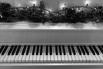 black and white piano keys close up with Christmas decoration  