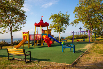 The children's playground is colorful on a green yard. Antalya - Turkey