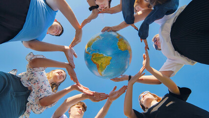 Students make a circle around the globe of the world. The concept of world peace.