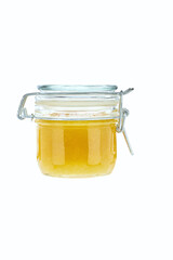 front view of small lemon jam jar without labels and shiny metallic lid covers isolated on white background.