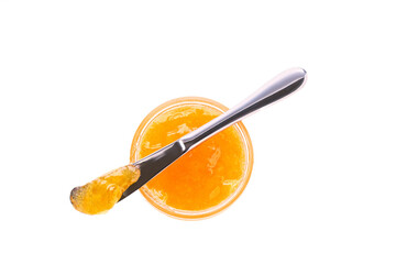 orange jam in jar with knife isolated on white background, top view.