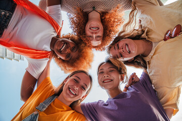 Low angle view of five teenage girls laughing and looking at camera. Group of young women smiling...