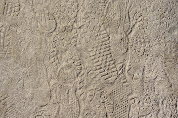 Dirt sand ground with shoe footprints. Background photo texture.