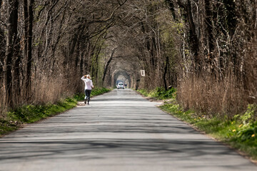 Outdoor sporting activity running through atmospheric avenue of trees on dutch the coutryside