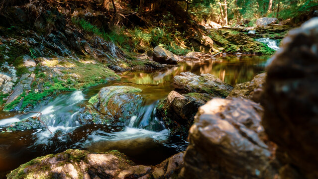 Flowing water in waterfall between rocky stream in the mountains