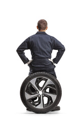 Rear view shot of a car mechanic sitting on a tire