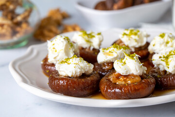 Stuffed dry fig dessert, cooked with syrup, traditional, pistachio and kaymak (Turkish name; kaymakli incir tatlisi )