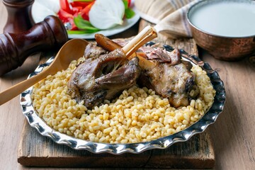 Turkish foods; lamb shank tandoori on bulgur wheat rice (Turkish name; bulgur bugday pilavi kuzu incik tandir)