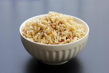 Cooked brown rice on dark background.