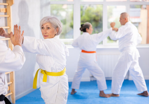 Dynamic photo capturing energy and focus of senior athletics students people fighting in karate class. Obtaining black belt, advanced training, highest dan of martial arts. Sport to max.