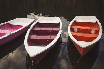 Boats on majestic mountain lake Lacul Rosu or Red Lake or Killer Lake. Splendid autumn scene of lake Lacul Rosu in Romania, Europe. Many multicolored boats anchored on the shore. Touristic place.