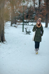 pensive modern woman outdoors in city park in winter