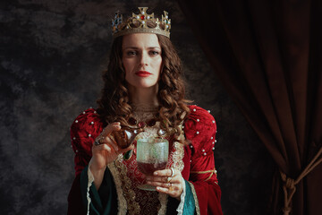 insidious medieval queen in dress pouring poison into goblet