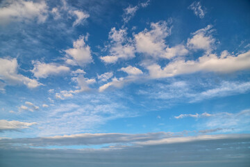 Blue sky with gray and white fluffy clouds. Abstract tranquil background
