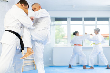 Dynamic photo capturing energy and focus of senior athletics students people fighting in aikido...
