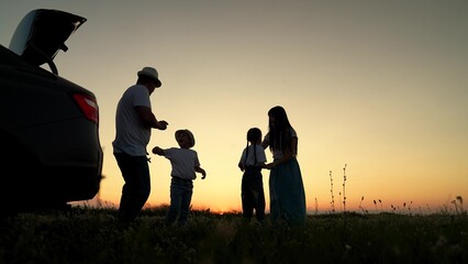 Dad with child, daughter on his shoulders, mom, children dance and admire beautiful sunset. Parents...
