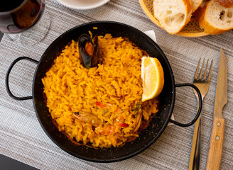 Just cooked paella de marisco served on table in restaurant.