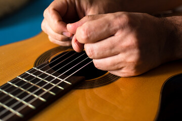 Hands on top of a classical guitar.