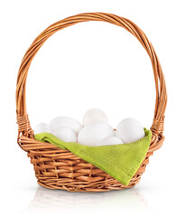 Fototapeta na wymiar wicker basket with fresh chicken eggs and a textile green napkin is highlighted on a white background by shadow and reflection