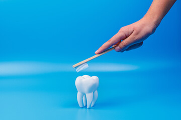 A woman brushes her teeth with an eco-friendly toothbrush. tooth on a blue background. Prevention of caries and tartar.