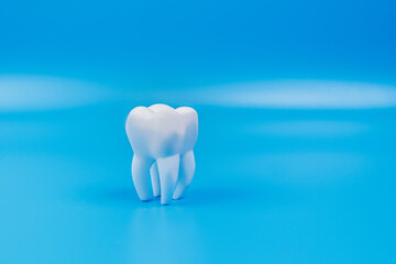 Tooth on a blue background. Space for text. anti-caries protection concept composition. 
concept of dental examination of teeth, health and dental hygiene.