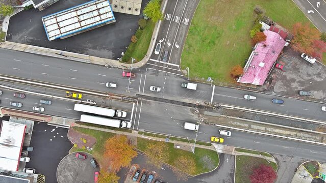 View from an aerial perspective depicts busy road intersection during rush hour with heavy traffic flowing through