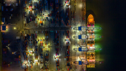 Container cargo ship in import export business logistic at night, Aerial view.