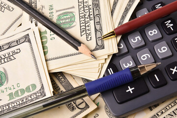 Paper money dollar banknotes, pens, pencil and calculator